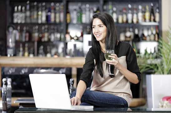 Image: Woman Drinking Wine in Bar on Laptop