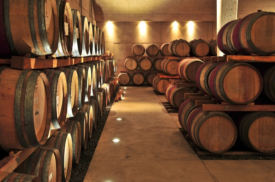 Image: Stacked oak wine barrels in winery cellar