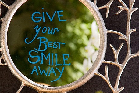 Give Your Best Smile Away written on a mirror.